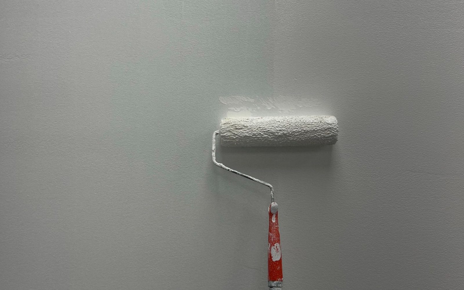 Paint roller applying fresh paint to an interior wall
