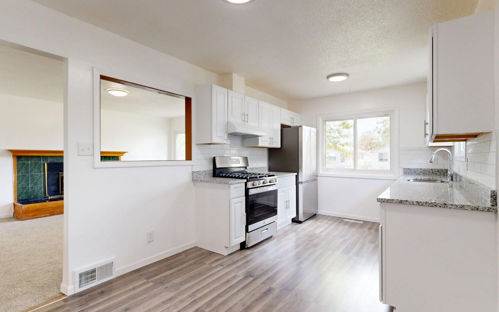Renovated kitchen with white cabinets and stainless steel appliances